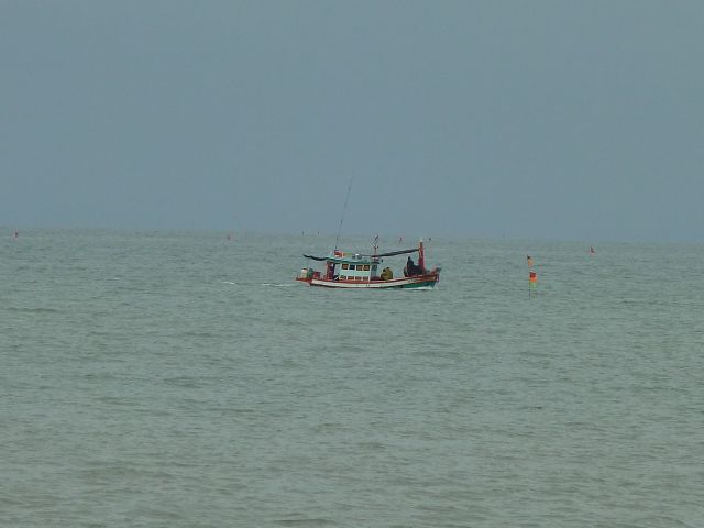 Fischerboot setzt Netz aus.